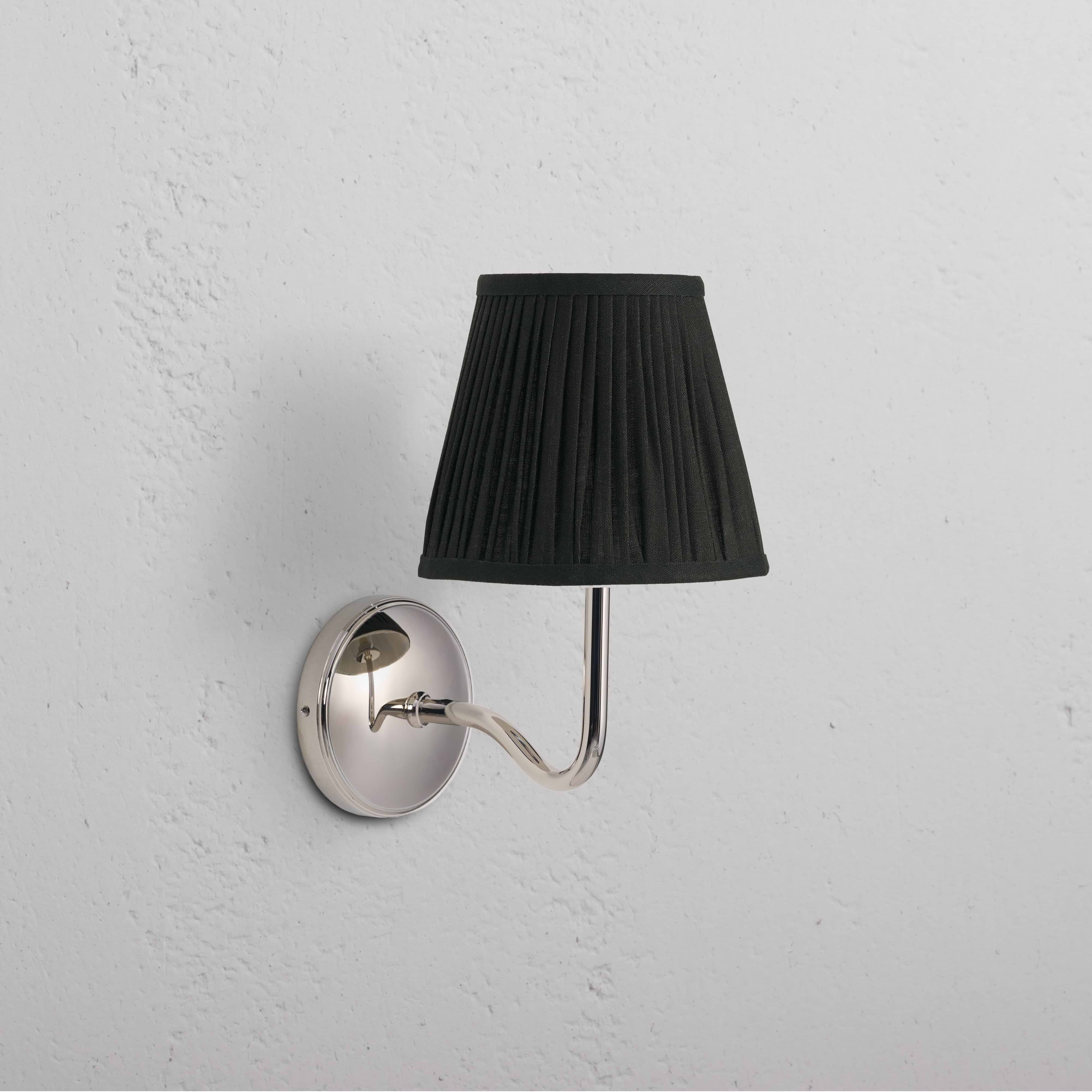 Malvern Medium Wall Light in Deep Green with polished nickel base and curved arm, mounted on a white wall.
