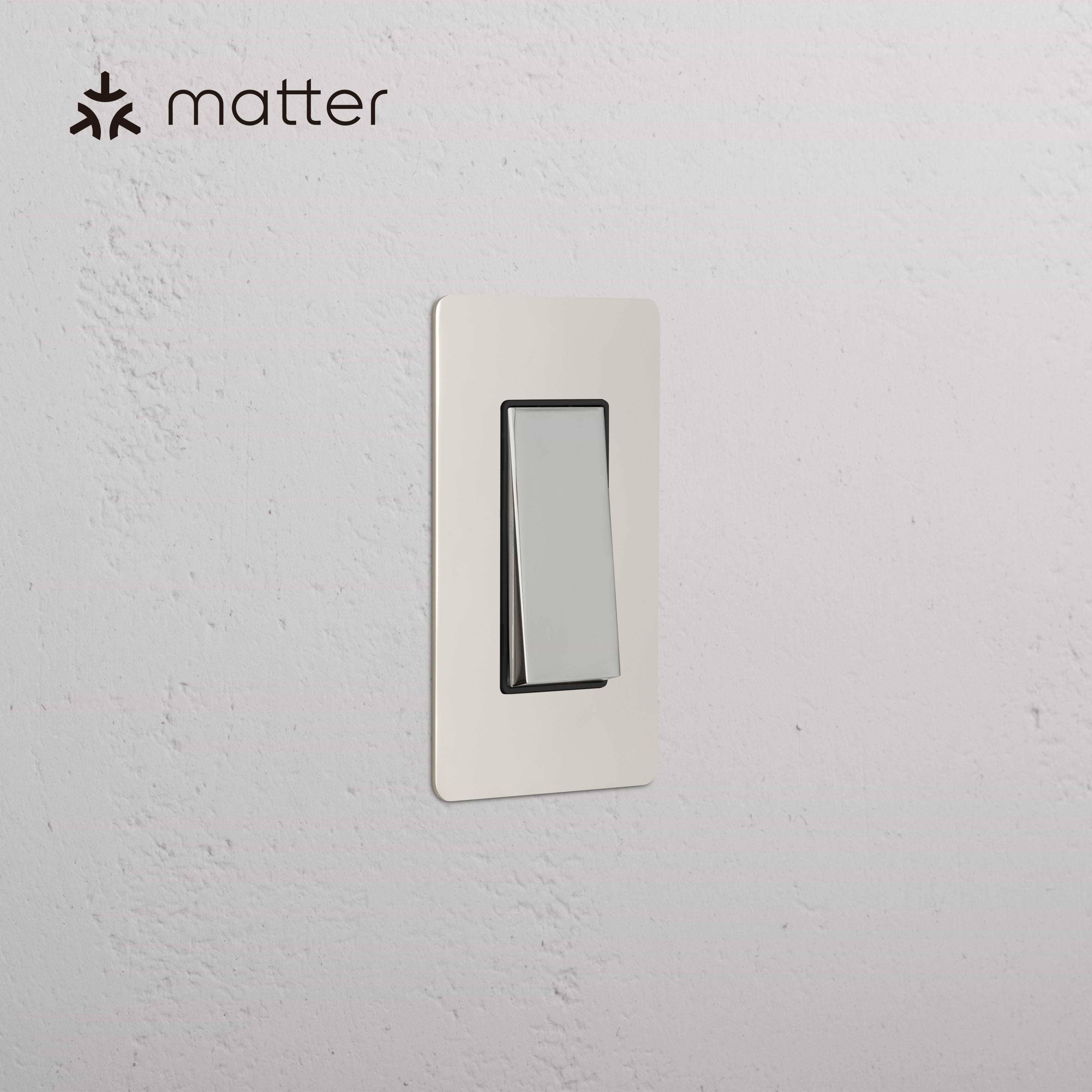 Kew 1G Smart Retractive Rocker Switch in polished nickel black, shown on a white wall with Matter logo.