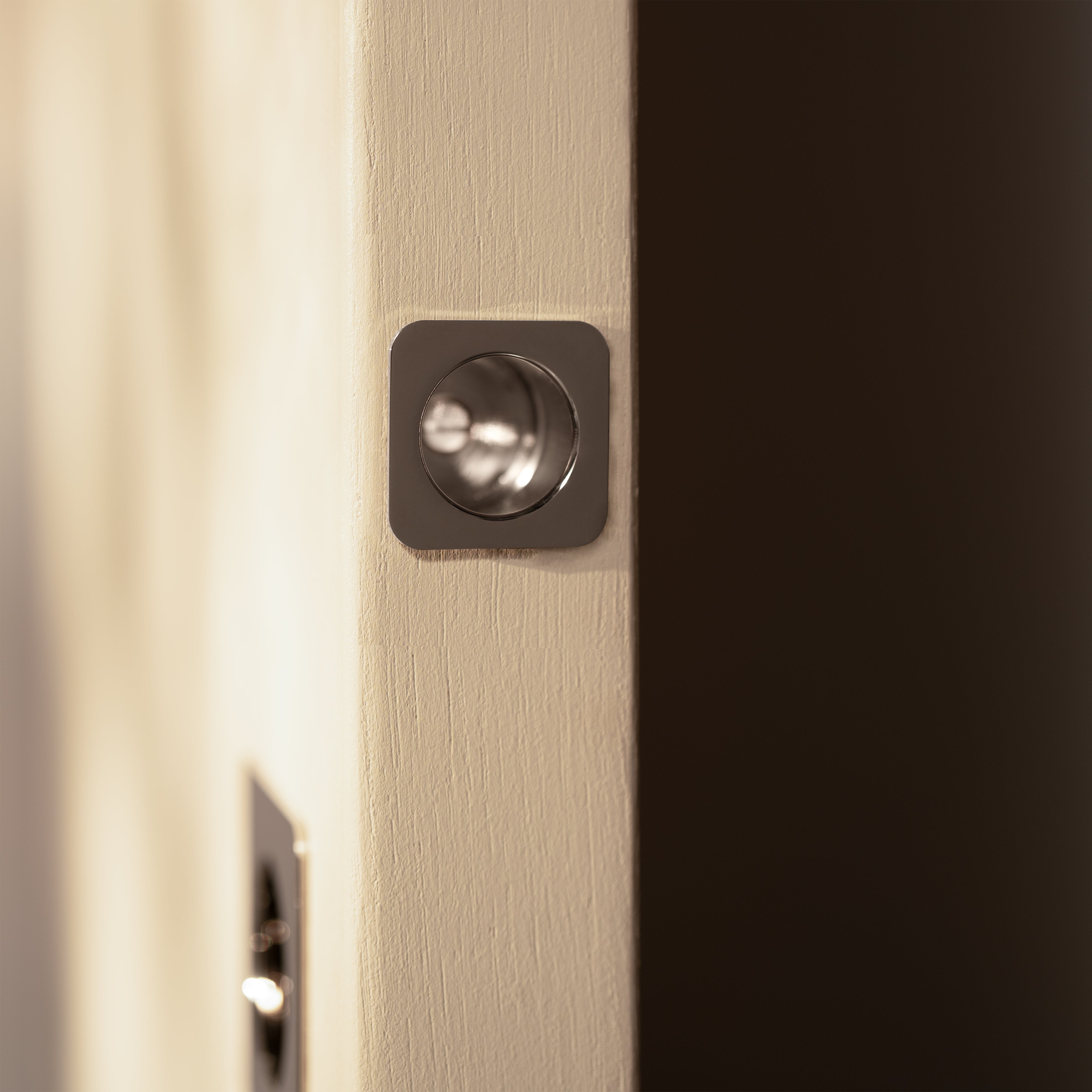 Regent Recessed Edge Pull in Polished Nickel installed on a beige door, showing its sleek metal design.