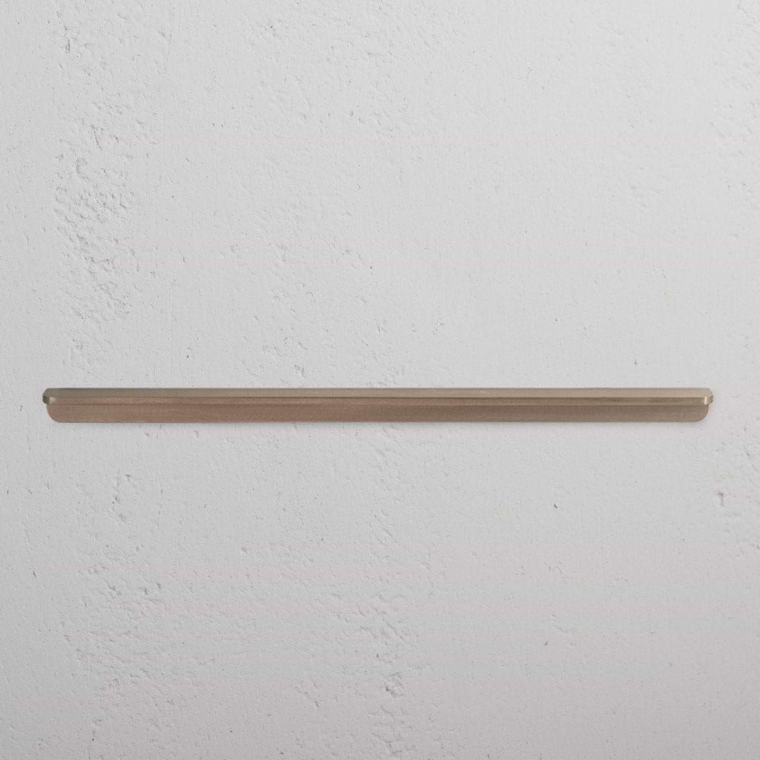 Oxford Furniture Handle Large in antique brass finish, mounted horizontally on a white wall.