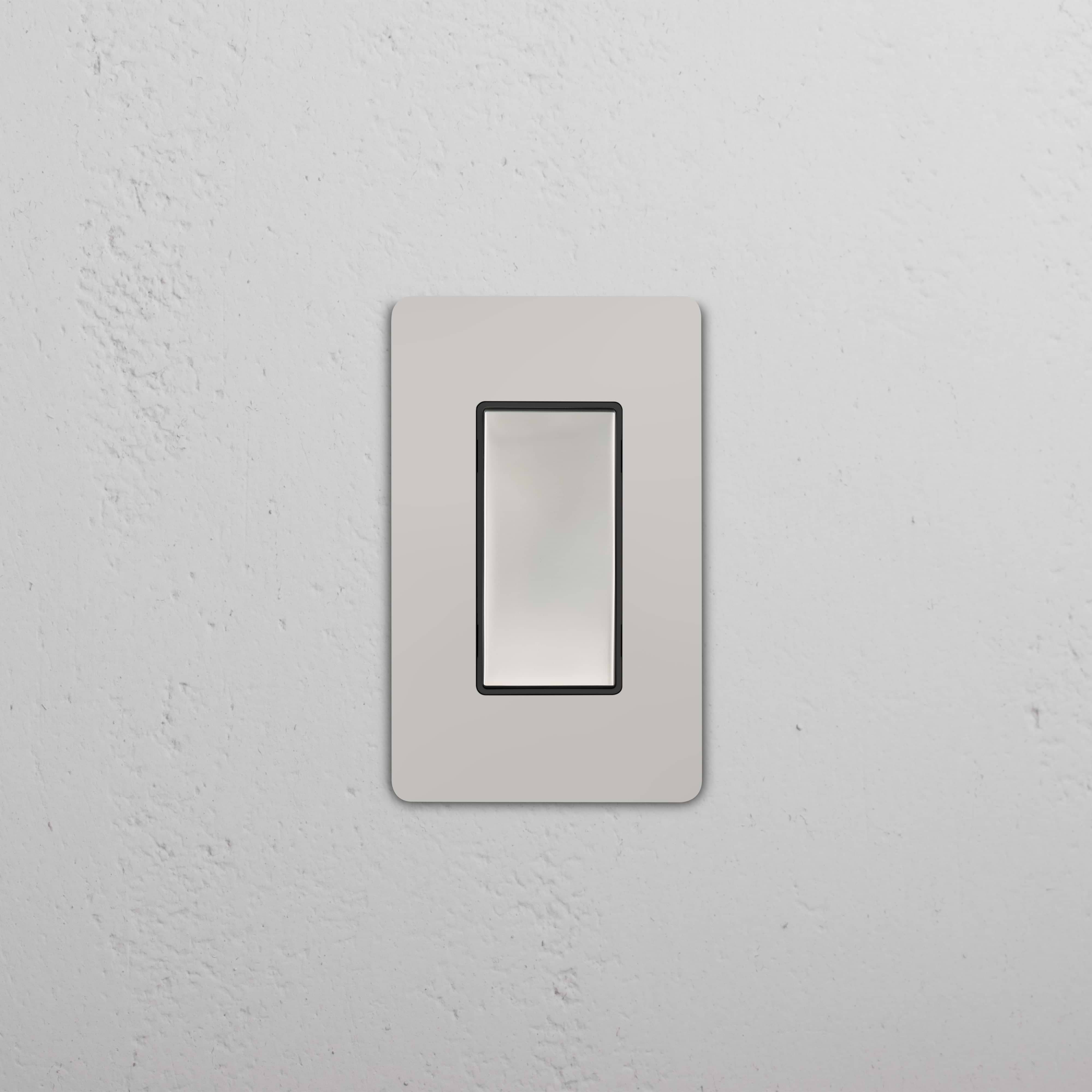 Grove 1G Center Retractive Rocker Switch in Polished Nickel Black finish, shown on a textured white wall.