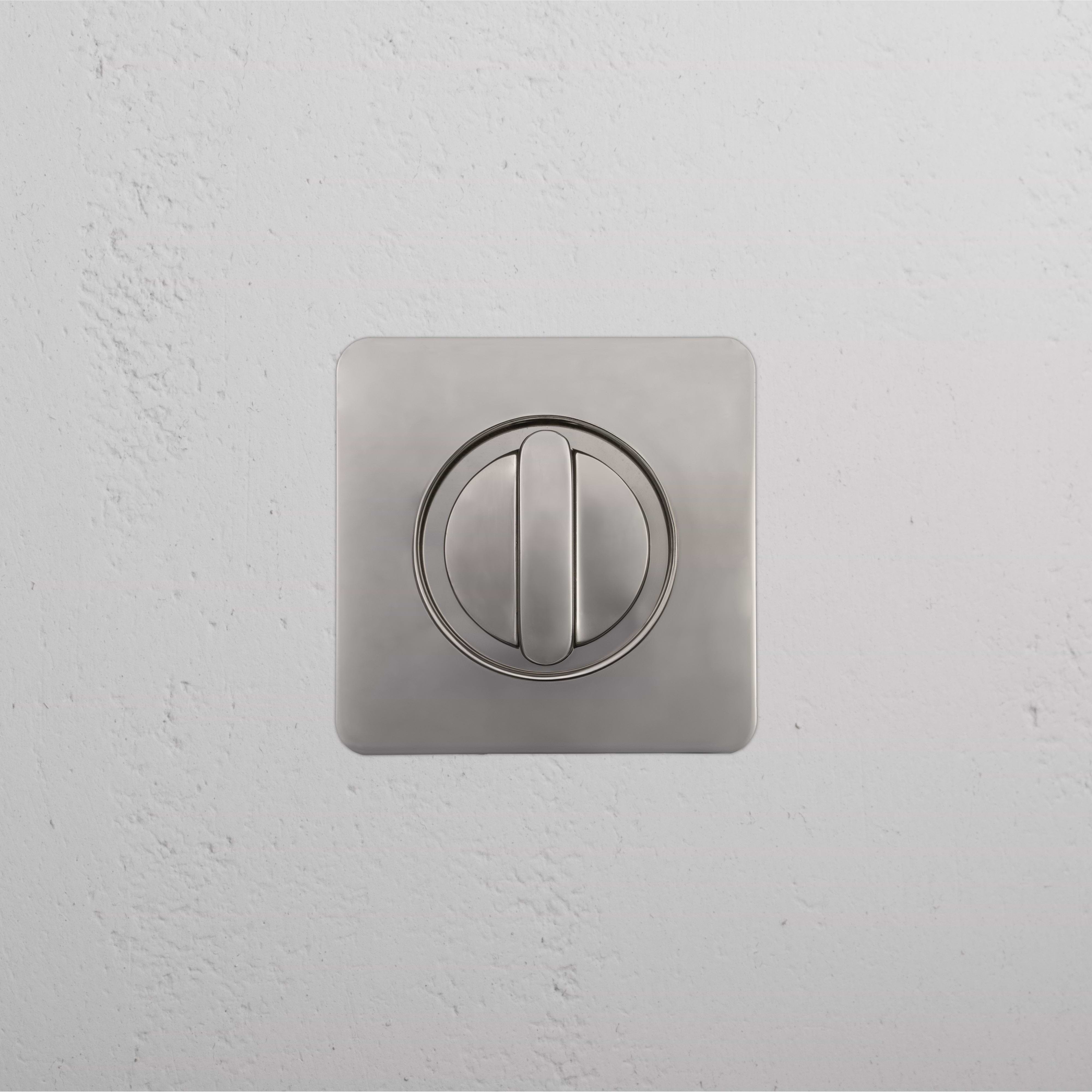 Close-up of a Regent Recessed Thumbturn in polished nickel finish, mounted on a white textured wall.