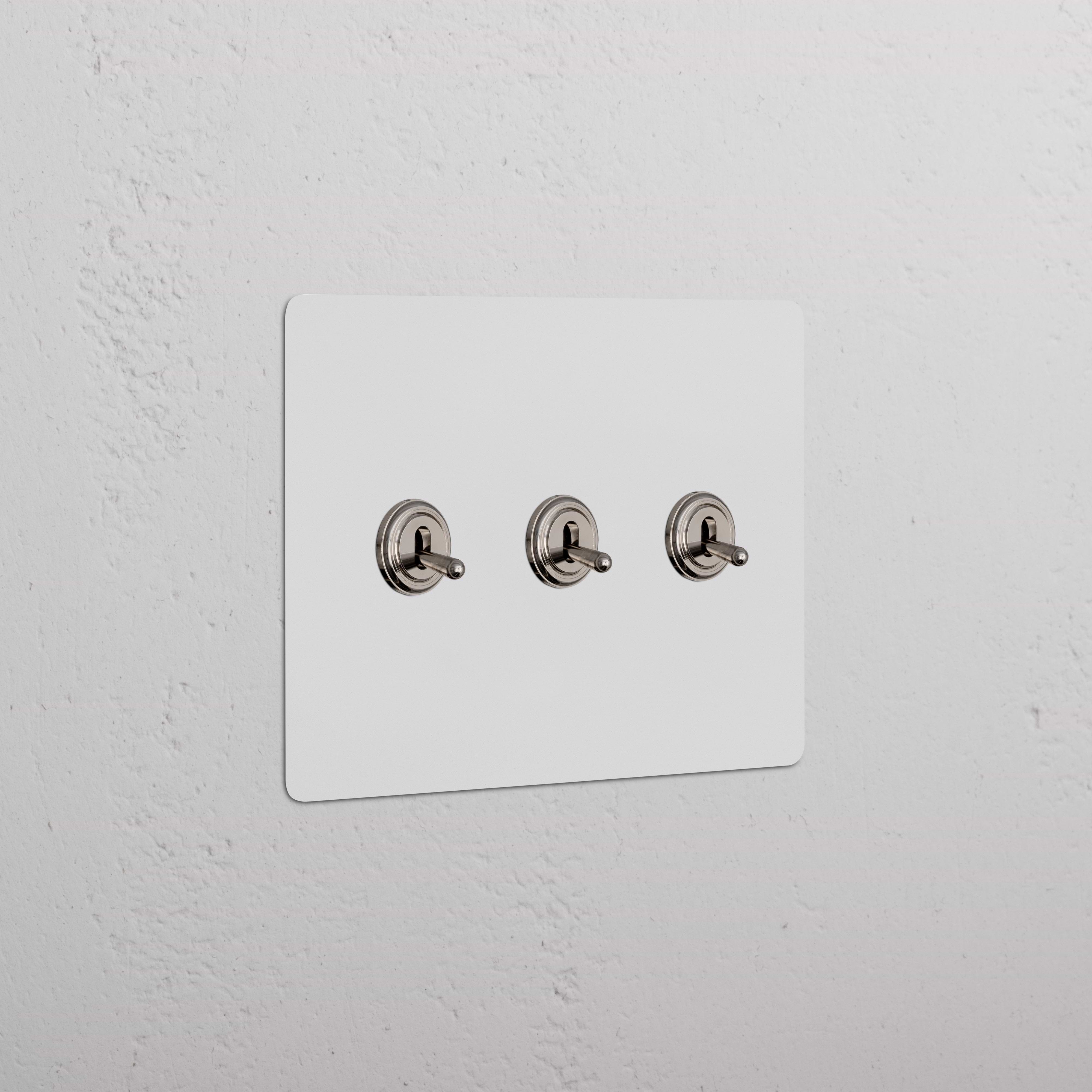 Kew 3G Toggle Switch in Paintable Polished Nickel with three horizontal switches on a rectangular plate.