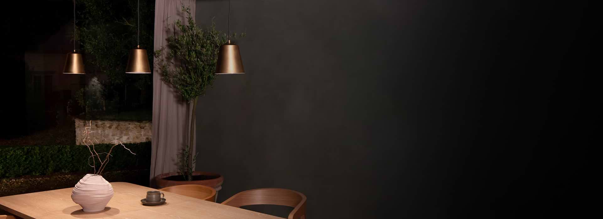 Pendant bronze light by Corston on grey background