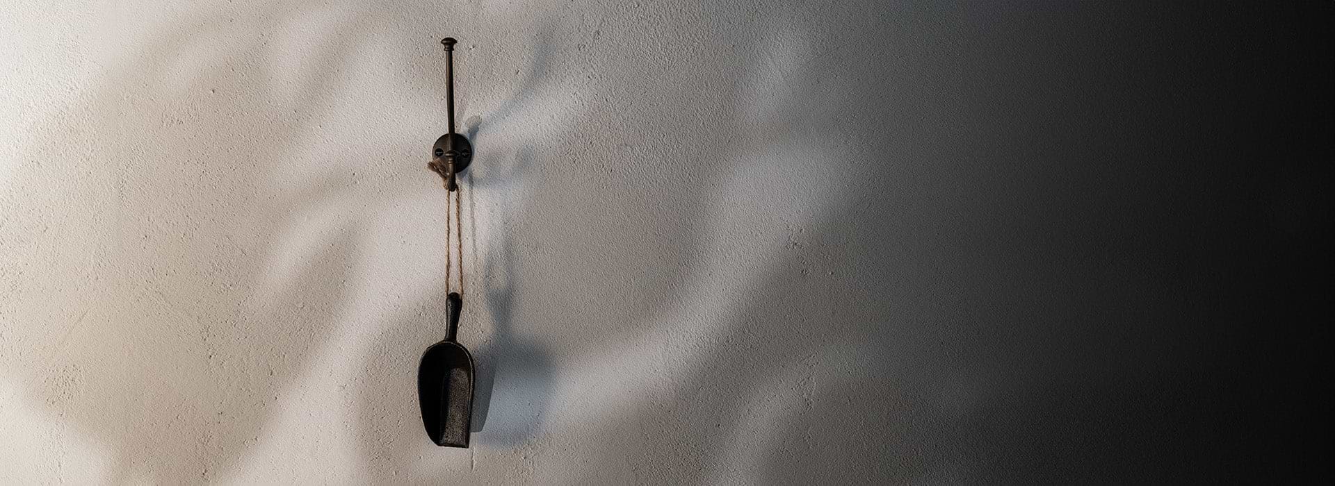 three bronze Hyde hooks, one holding a coat