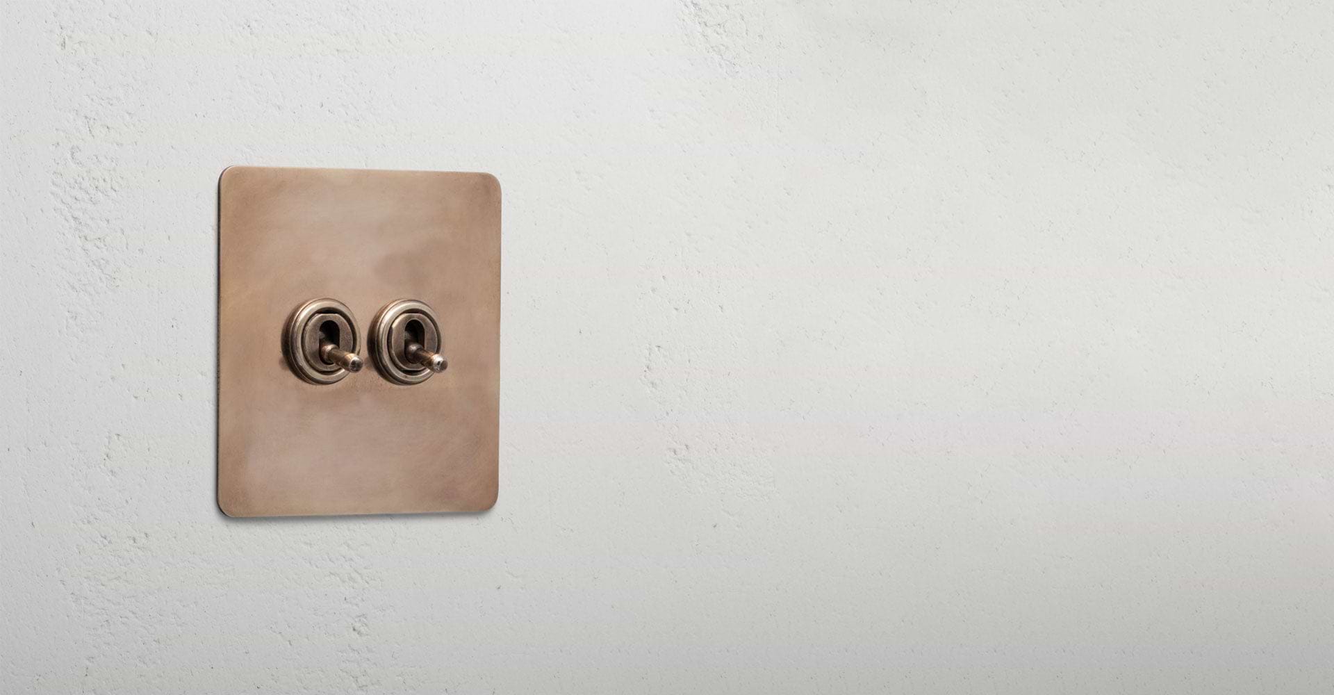 Antique Brass black fan isolator switch above 1G toggle 1G dimmer light switch to the right of curtis door hinge pair