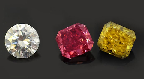 LEIBISH colorless Round diamond next to a Fancy Vivid Pink and a Fancy Vivid Yellow Radiant shape Diamonds
