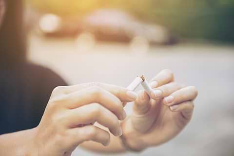 woman breaking cigarrette to detoxify her body
