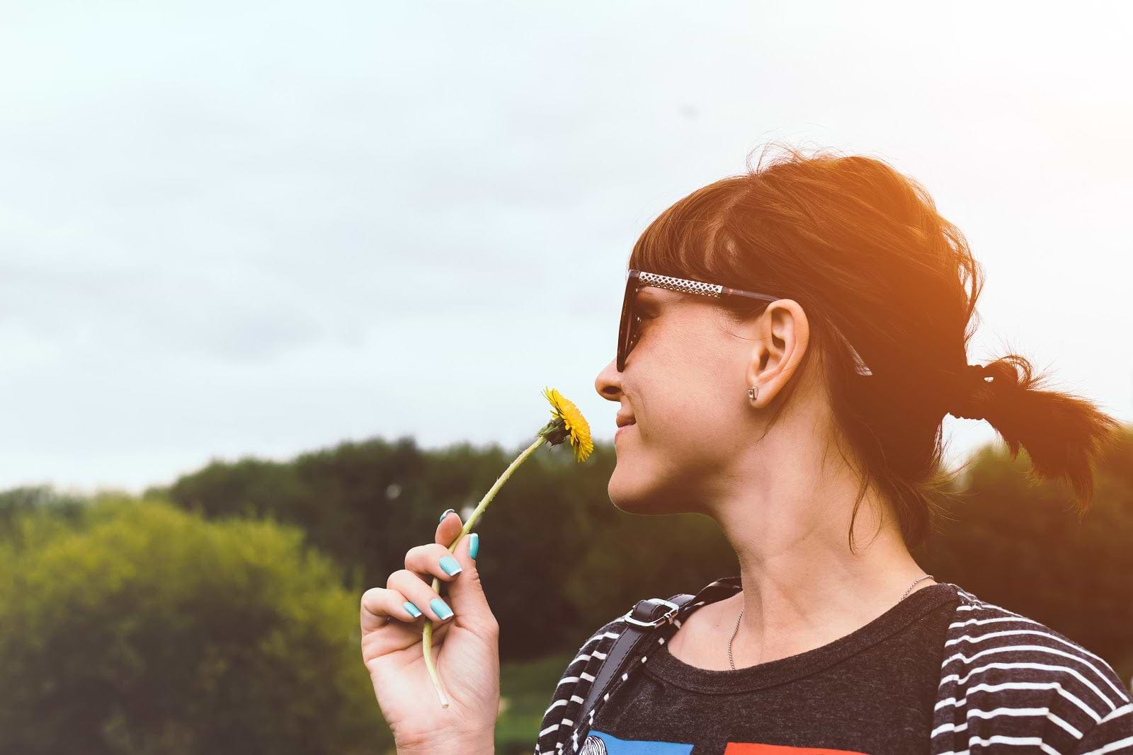 Autoimmune diet: A woman smells a flower