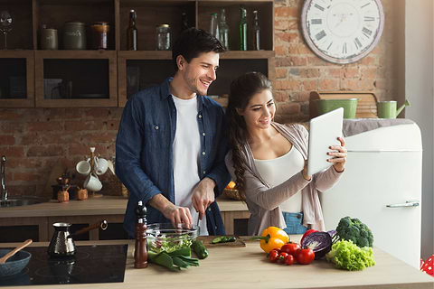 Couple reading a recipe and cooking together