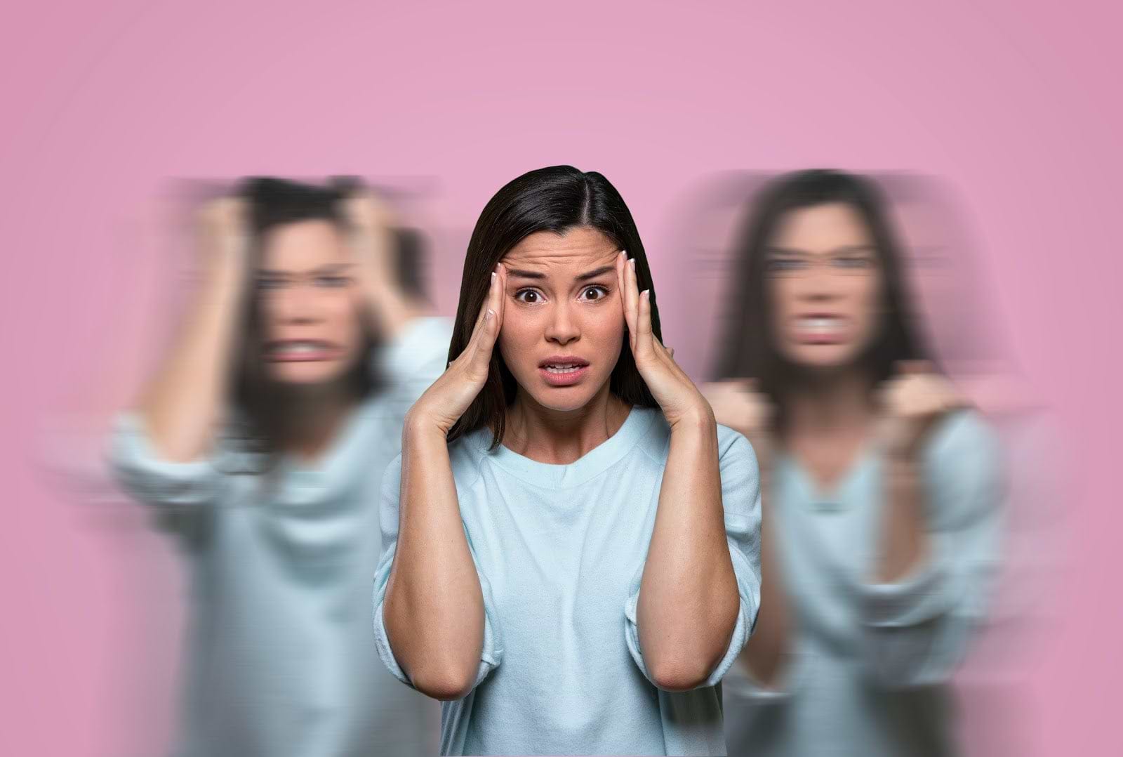 Low Progesterone Symptoms: Woman who looks stressed with hands at her temples