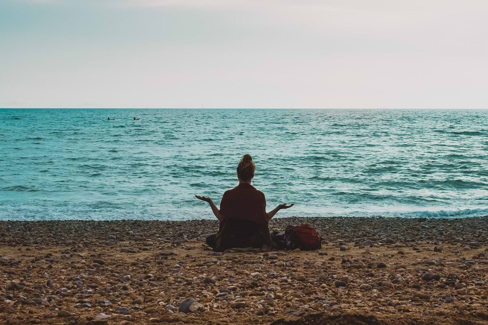 Autoimmune diet: A woman meditates on the beach