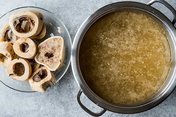 Where to buy bone broth: a pot of broth next to a bowl of bones