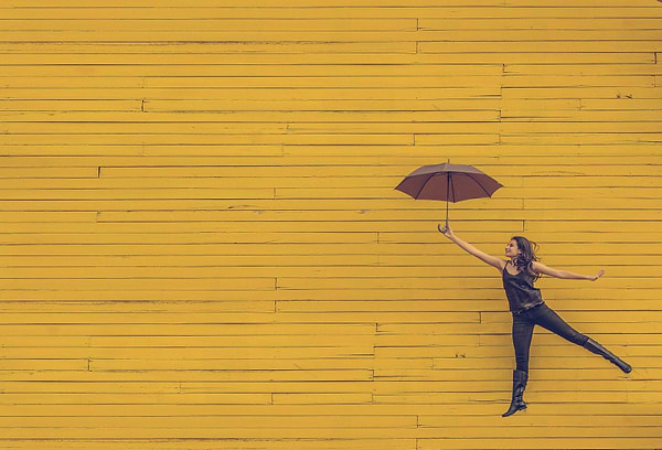 How to get rid of bloating: A woman floats with an umbrella