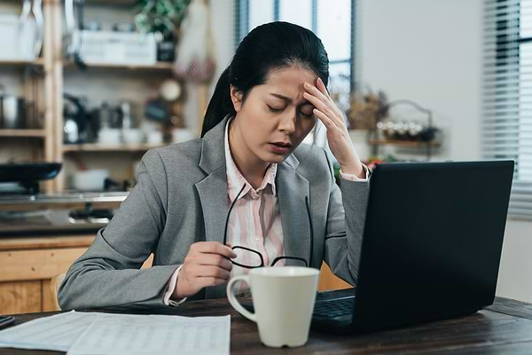 Asian businesswoman suffering from stress and hormonal imbalance putting her hand on her forehead