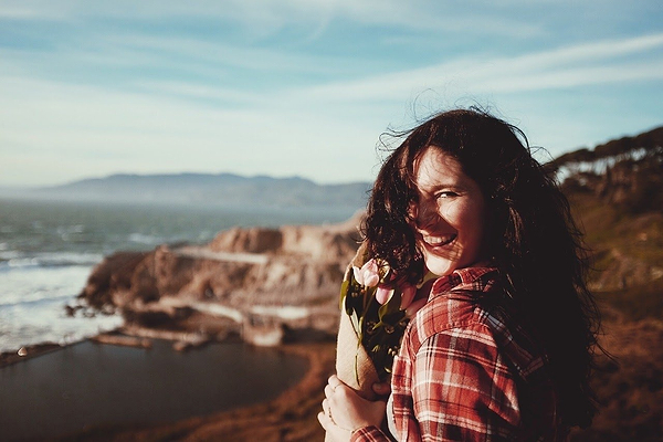 How to balance hormones: A smiling woman at the beach