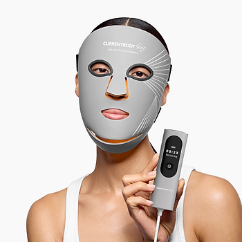 Woman holding the CurrentBody Skin LED Multi-Light Mask controller showing the different modes