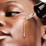 close up of woman applying the currentbody green tea serum