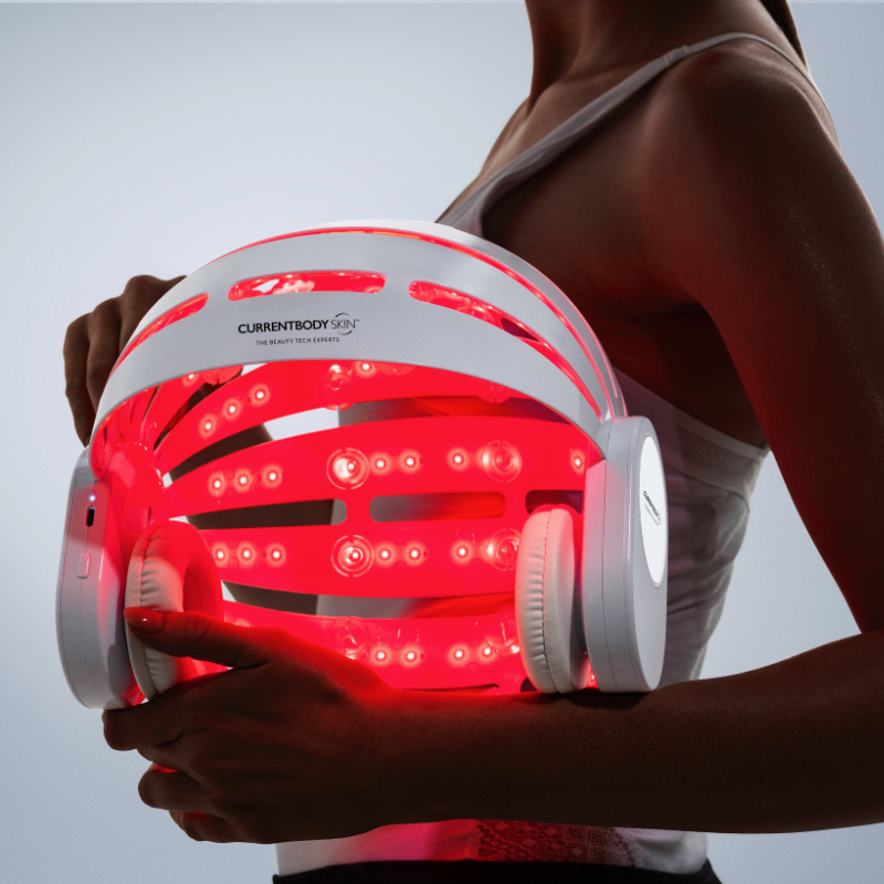 Woman holding the CurrentBody Skin LED Hair Regrowth Helmet