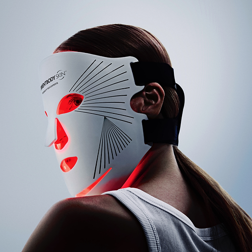 Woman using red light therapy mask for wrinkles on face