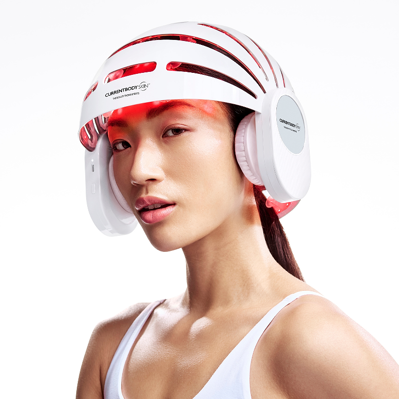 Woman using CurrentBody LED Hair Growth Helmet on her head