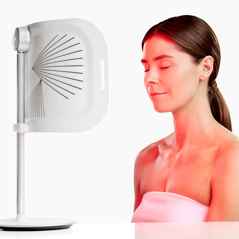 CurrentBody LED light therapy panel in front of a woman during skin treatment