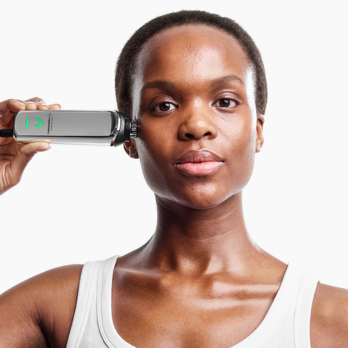 Mature woman demonstrating use of CurrentBody RF radio frequency device for facial skin firming
