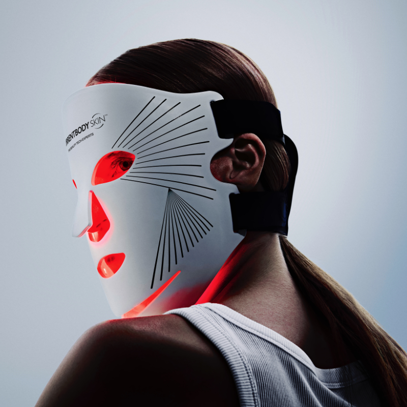 Woman using red light therapy mask for wrinkles on face
