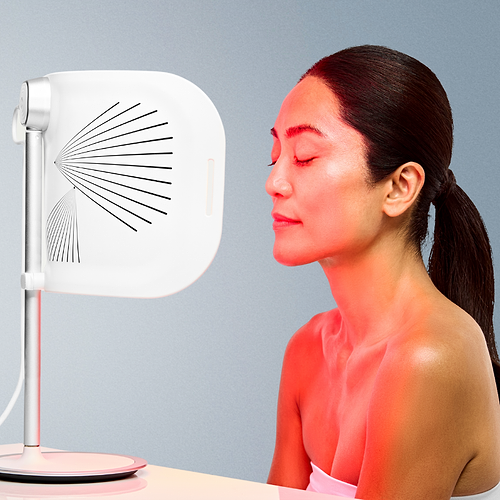 Woman using the CurrentBody LED Light Therapy Panel on her face