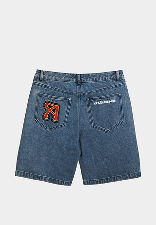 Ashluxe patch denim shorts in blue featuring multicolor embroidered patches and contrast thread detailing on pockets - back view.