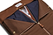 a view of the inside of the brown suede trifold half zipped with clothes inside