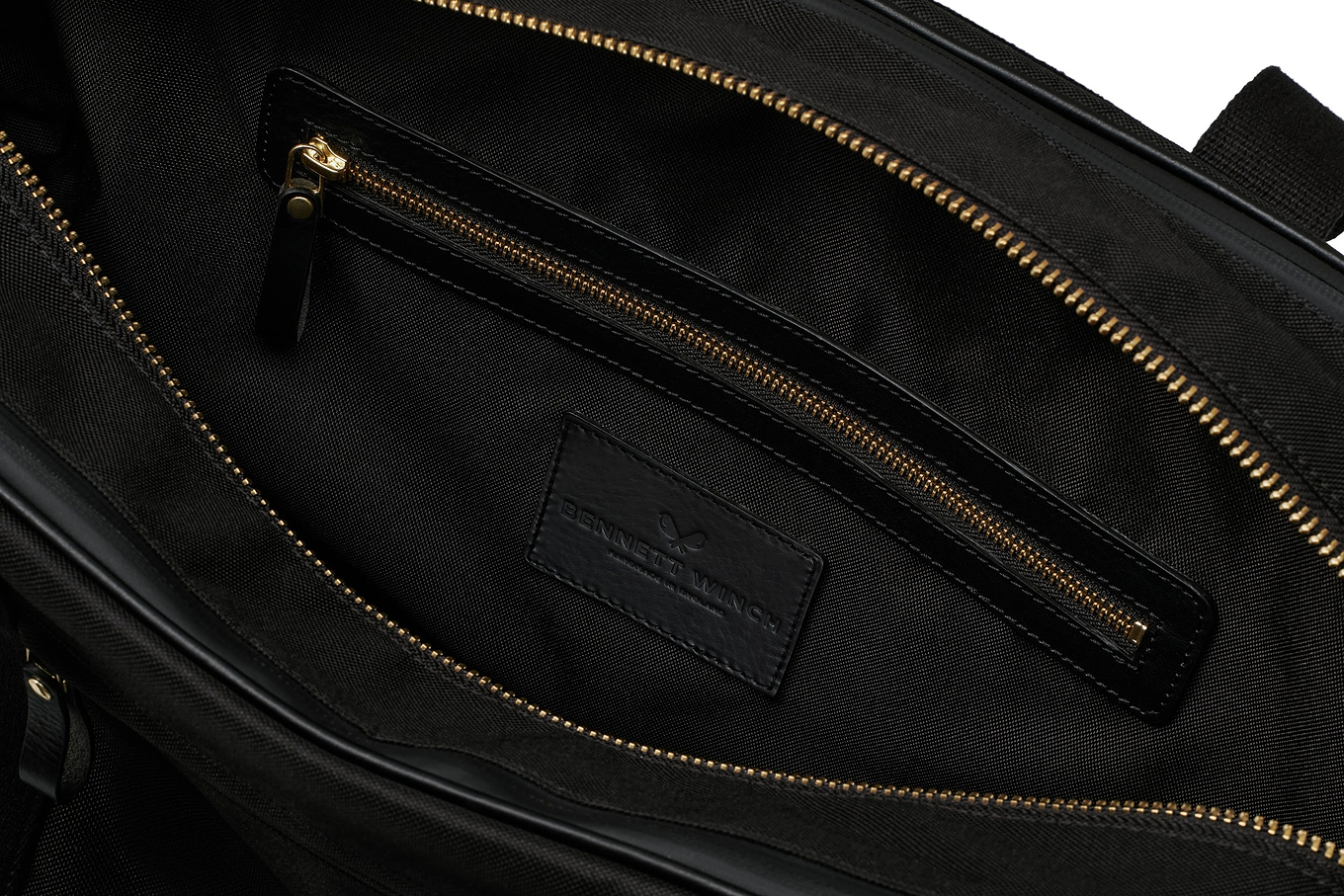 open view of the designer tennis bag in black, showing the inside pocket