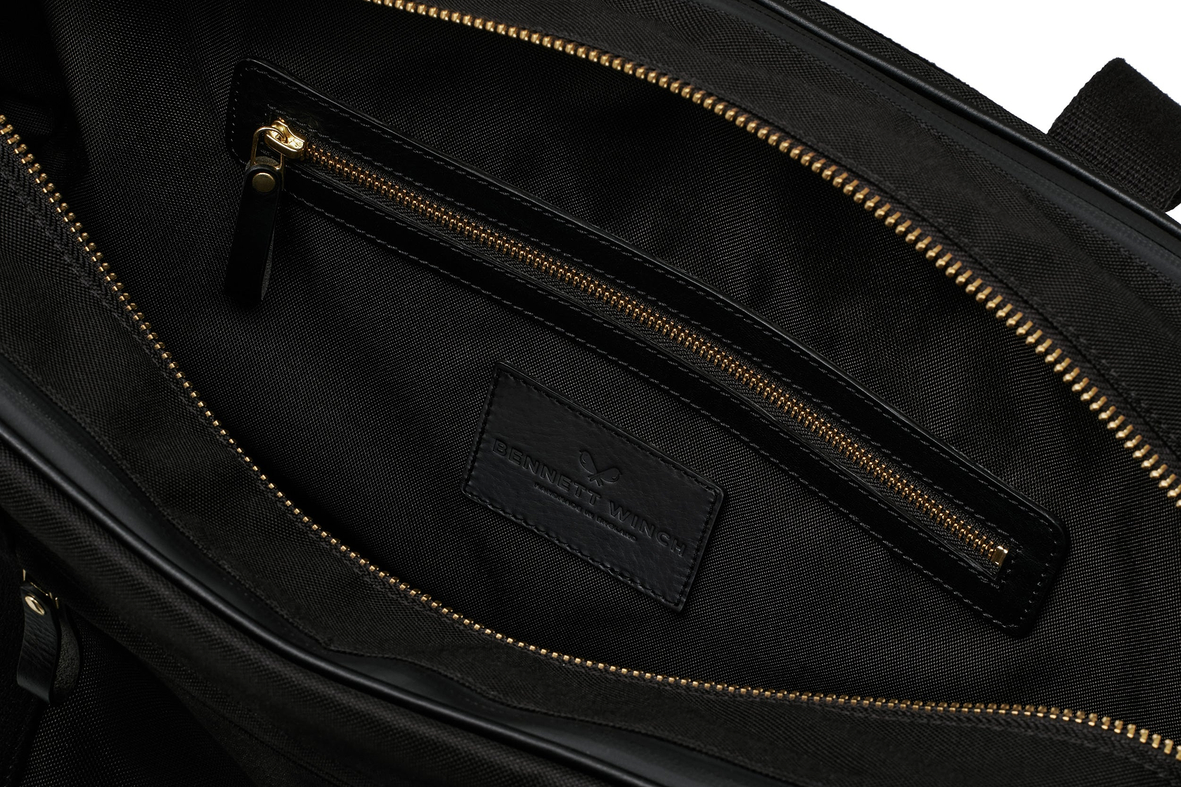 open view of the designer tennis bag in black, showing the inside pocket