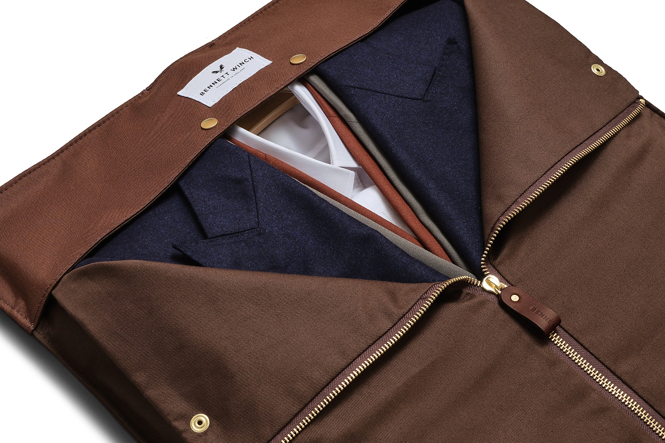 a view of the brown leather trifold half zipped with clothing inside 
