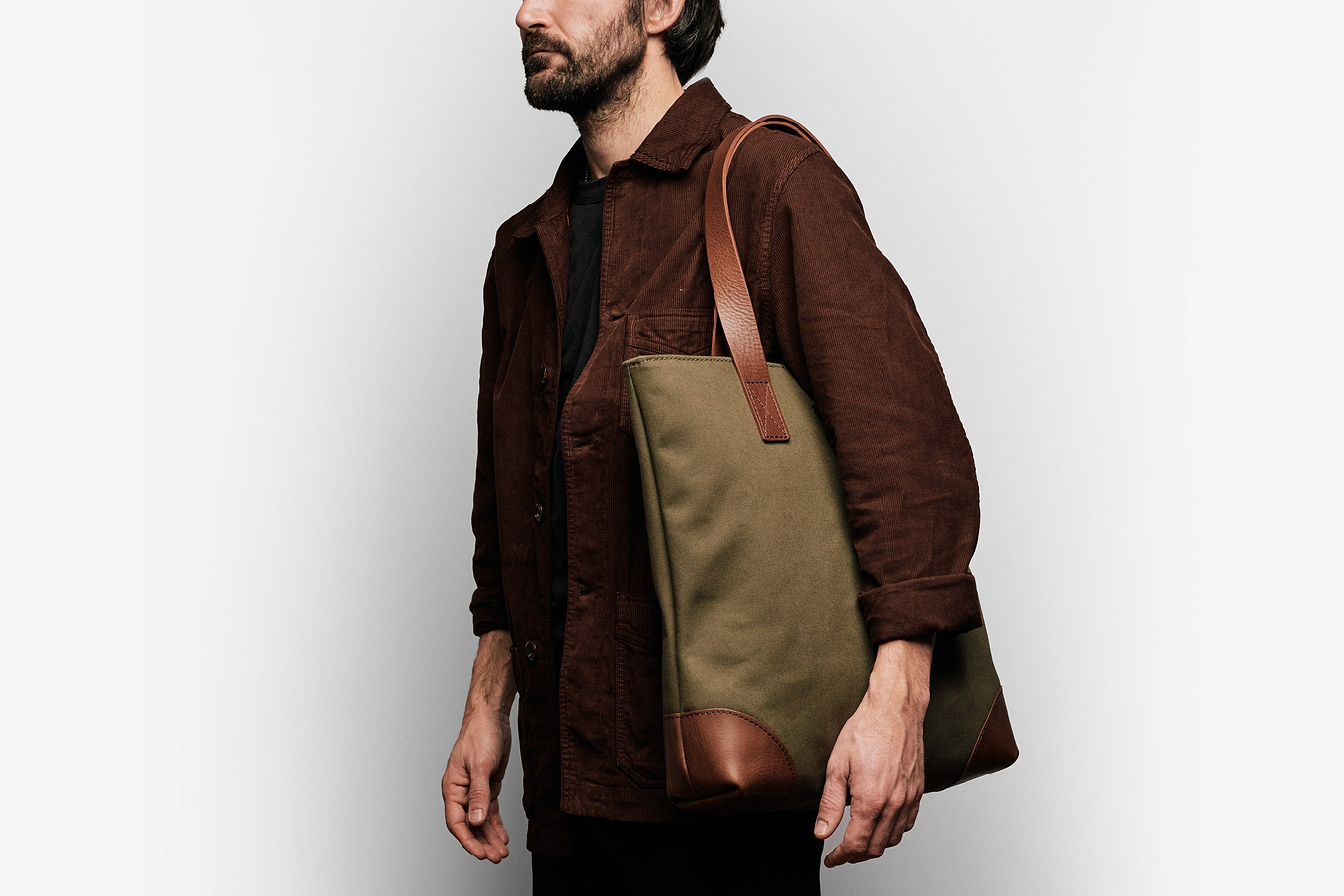 man wearing the green tote on his shoulder