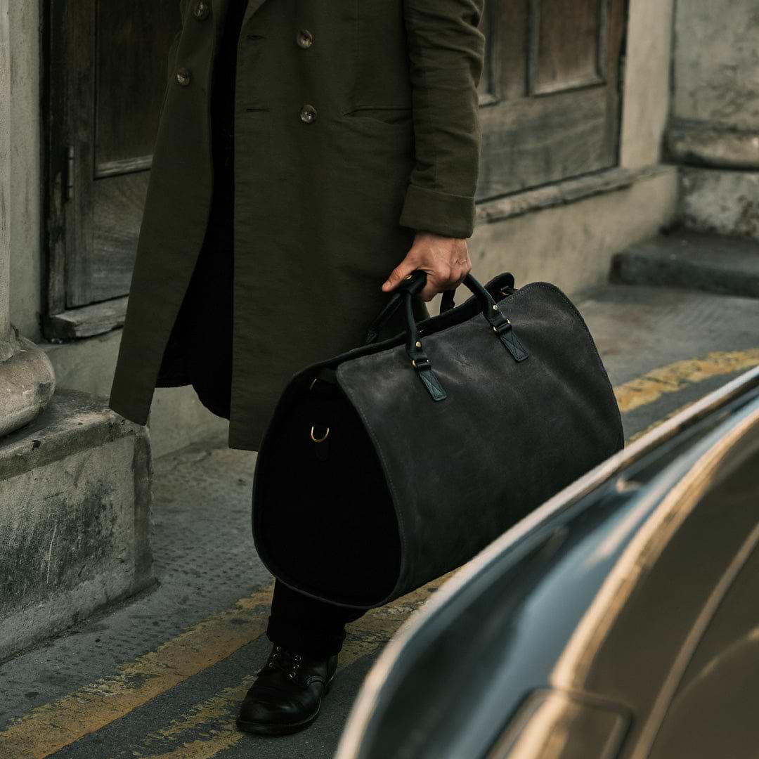 CEO walking with the suede Bennett Winch Suit Carrier