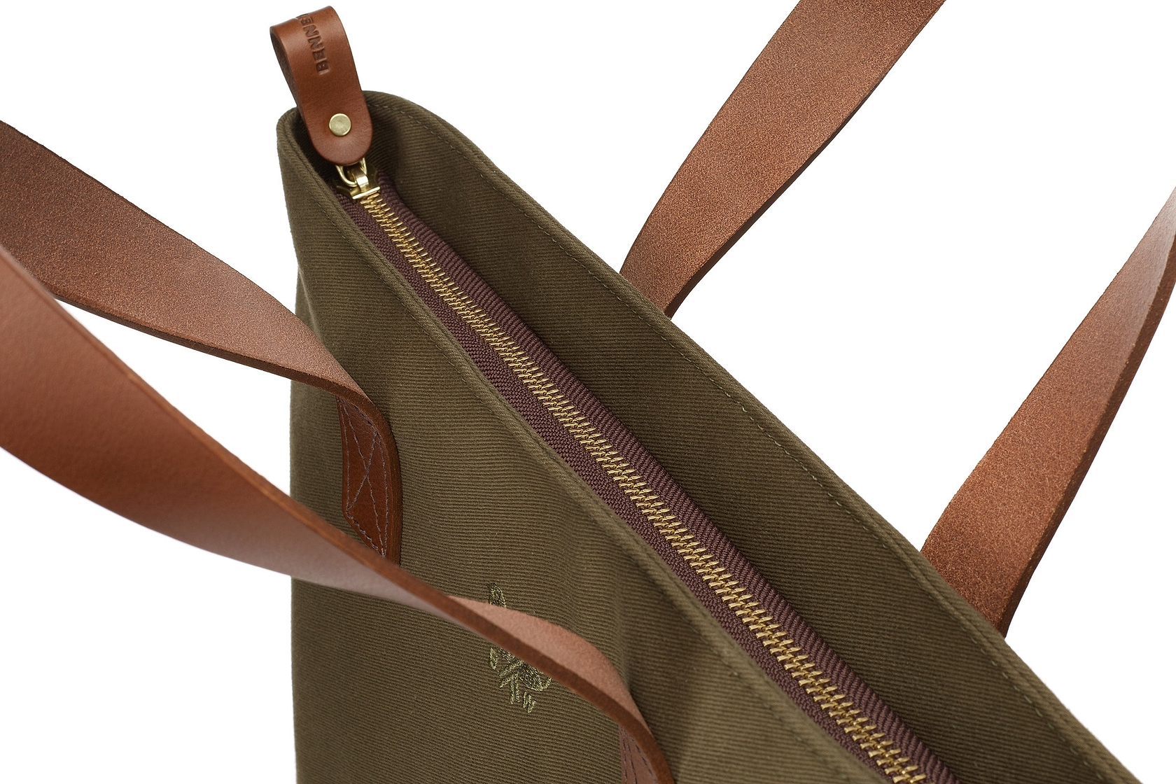 overhead view the tote's zipper top and leather handled closure