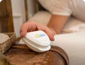 device on night stand held in hand