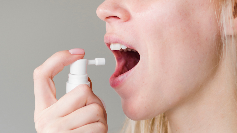 woman using throat spray