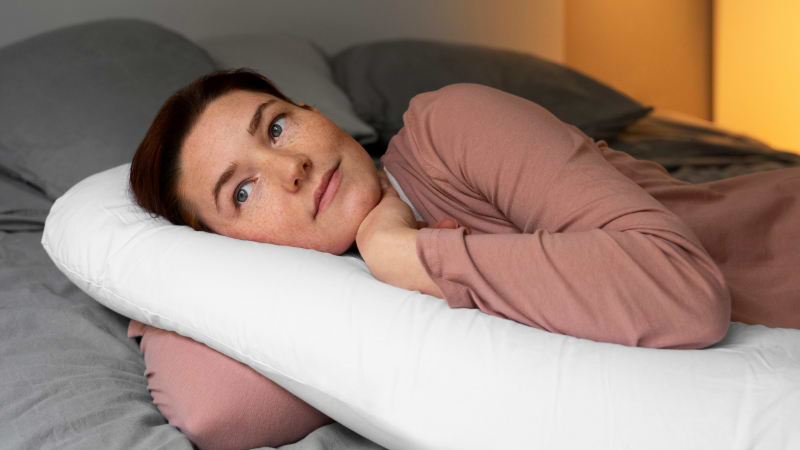 woman lying on one of the best pillows for snoring and neck pain
