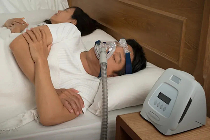 man sleeping with cpap machine