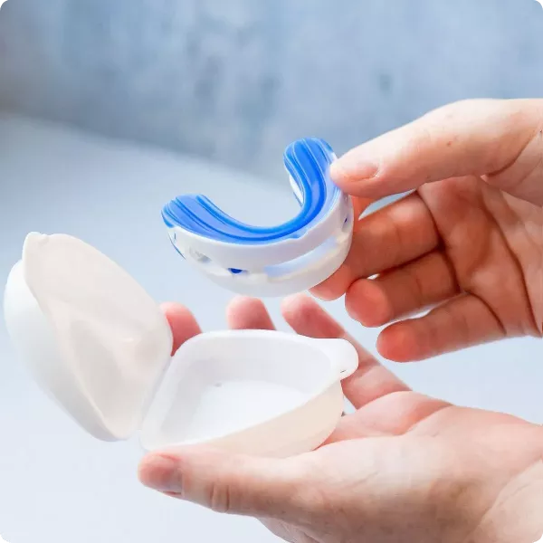 Image of a mouthguard for snoring held in hands, emphasizing its effectiveness and ease of use