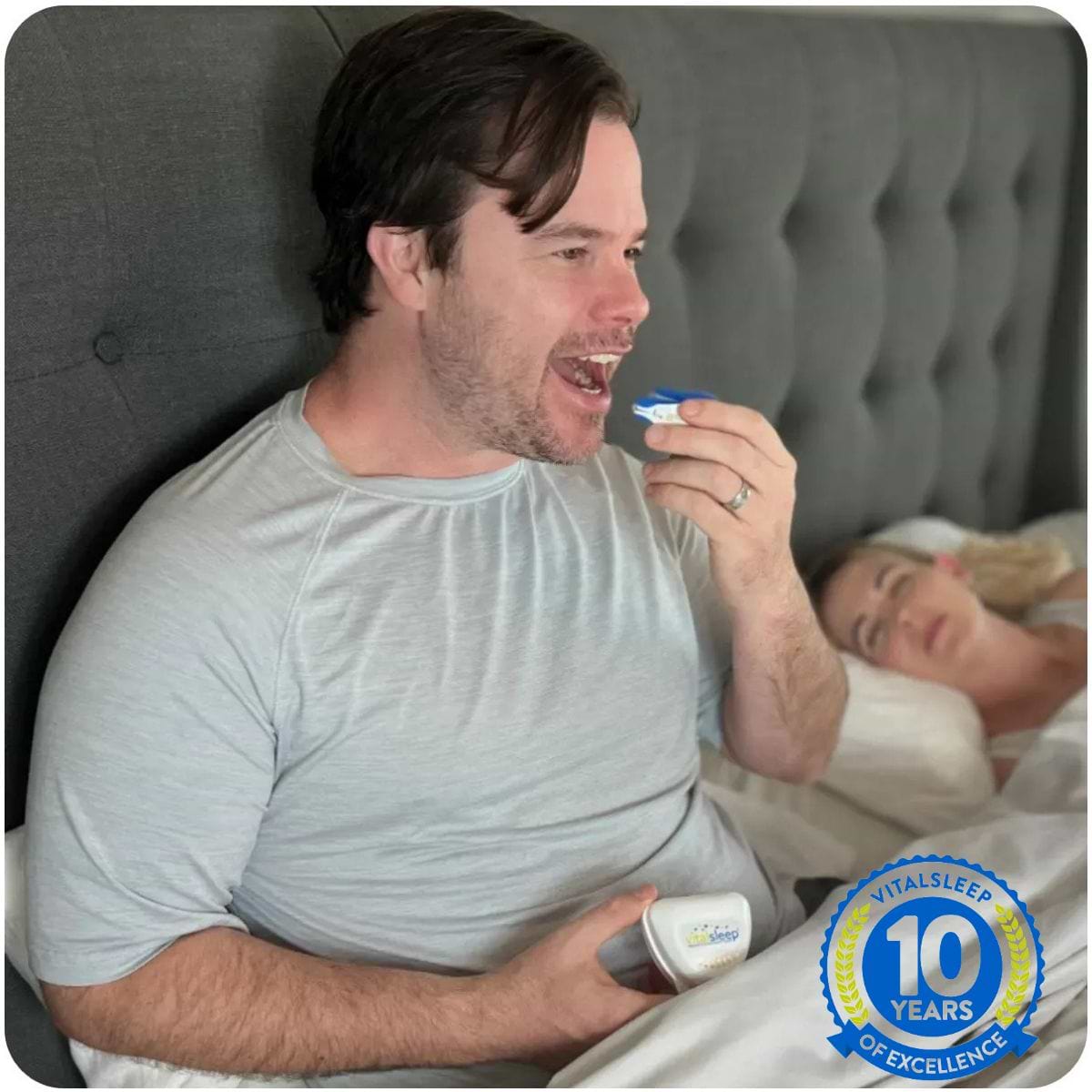 man using snoring mouthpiece in bed