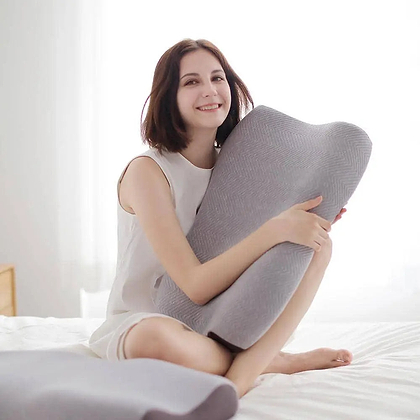 Woman holding gray memory foam pillow for better sleep