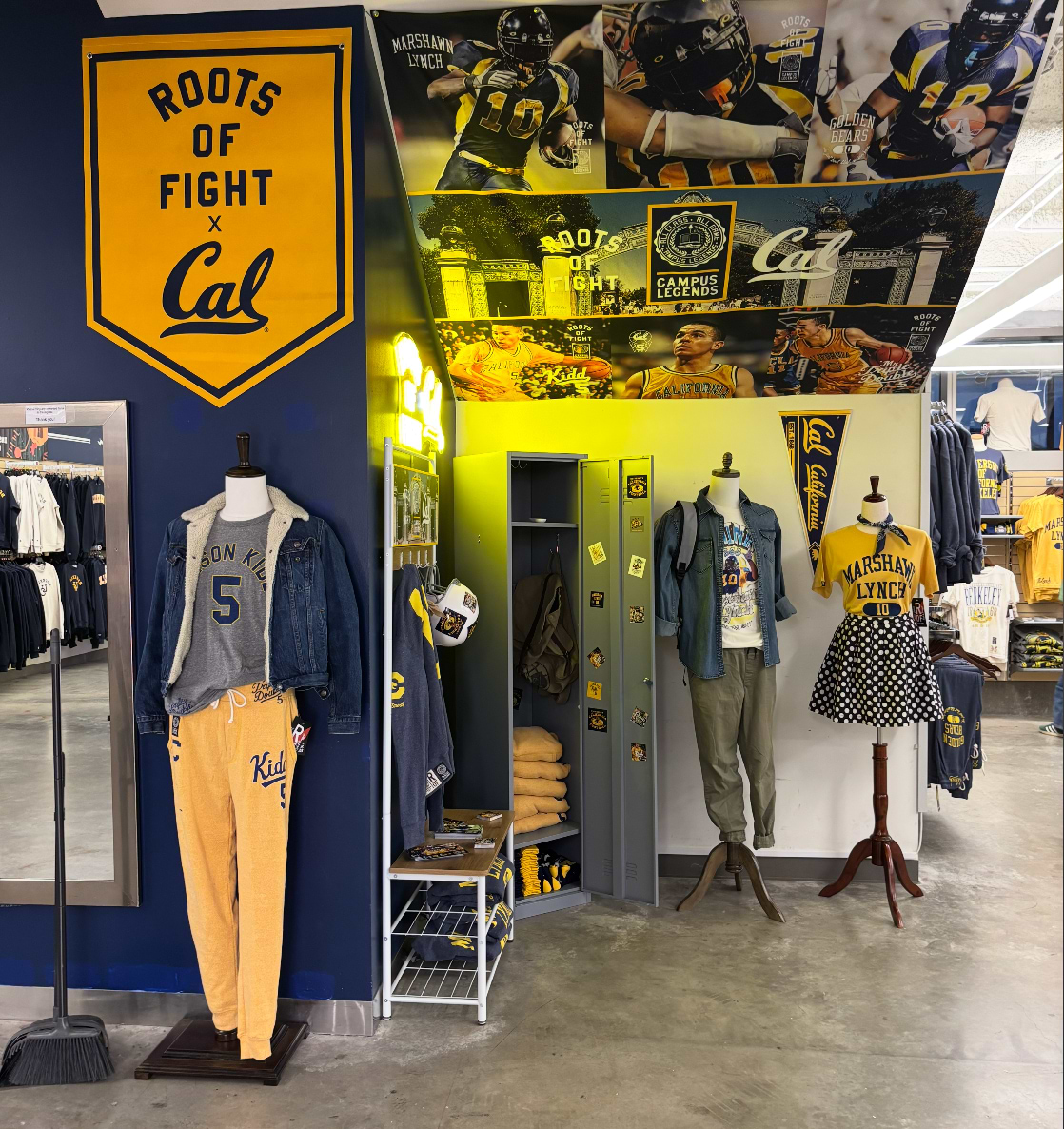 University apparel display with sports-themed clothing and memorabilia in a store.