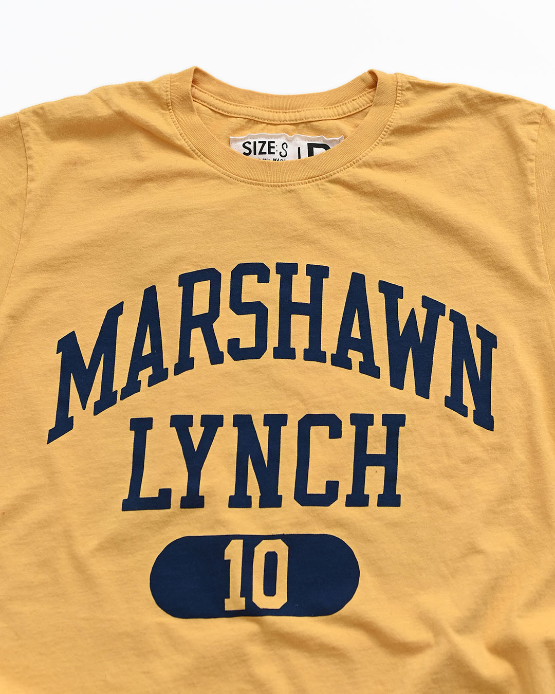 CAL - Marshawn Lynch #10 Gold Tee - Roots of Fight