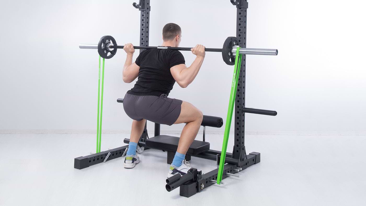 Squats on the squat rack with resistance band