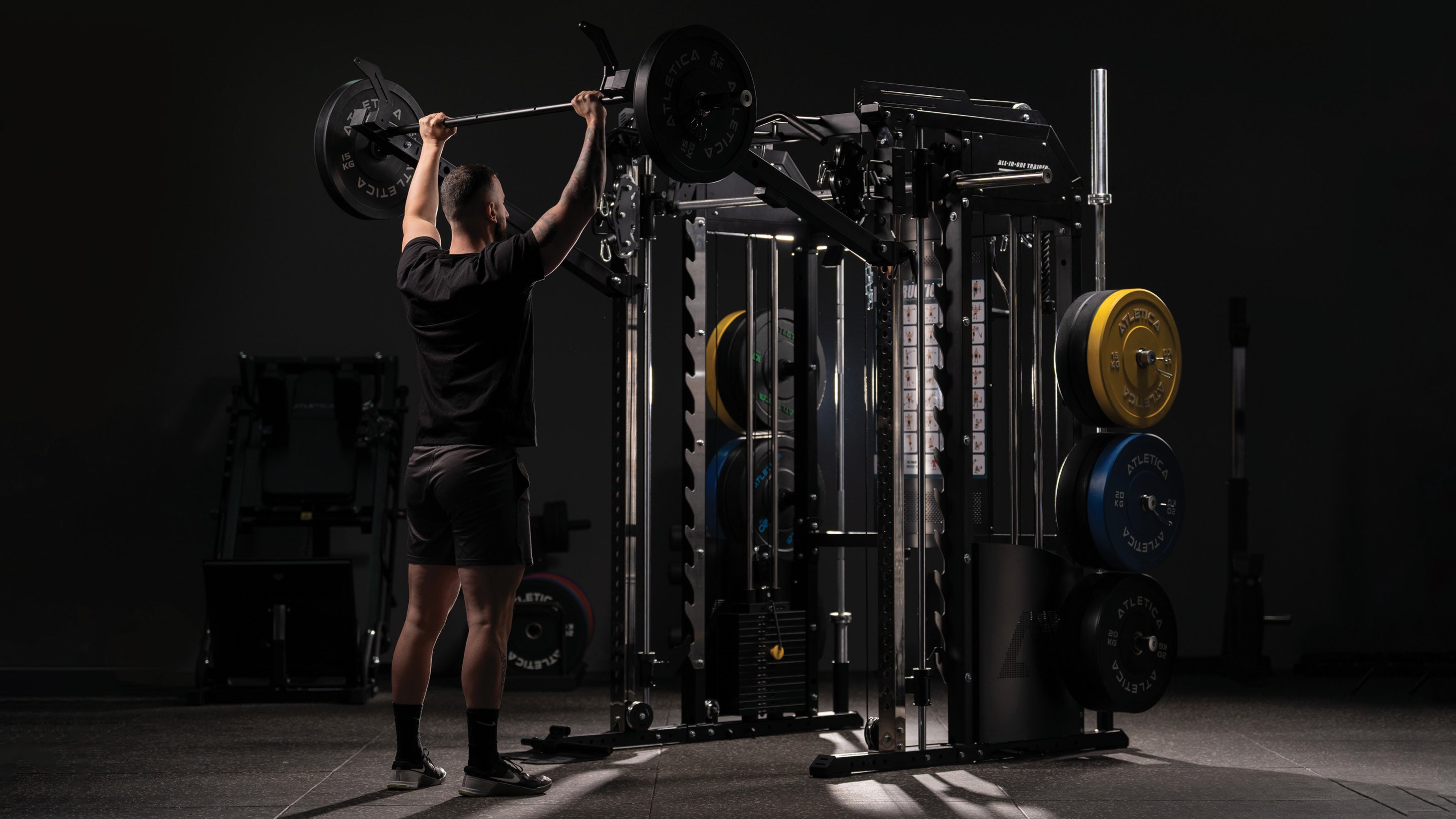 Training mit der Langhantel vor der Kraftstation