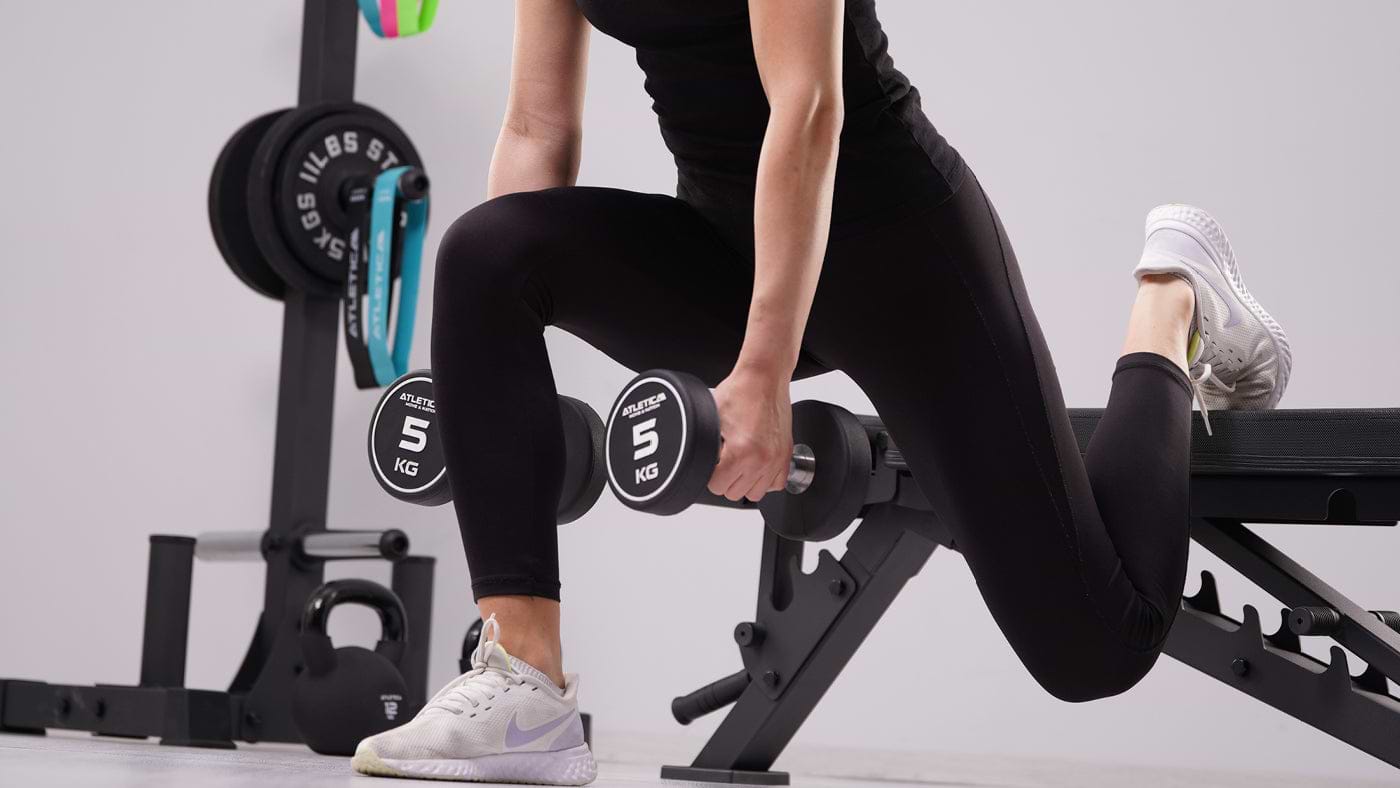 Lunges with dumbbells on the weight bench
