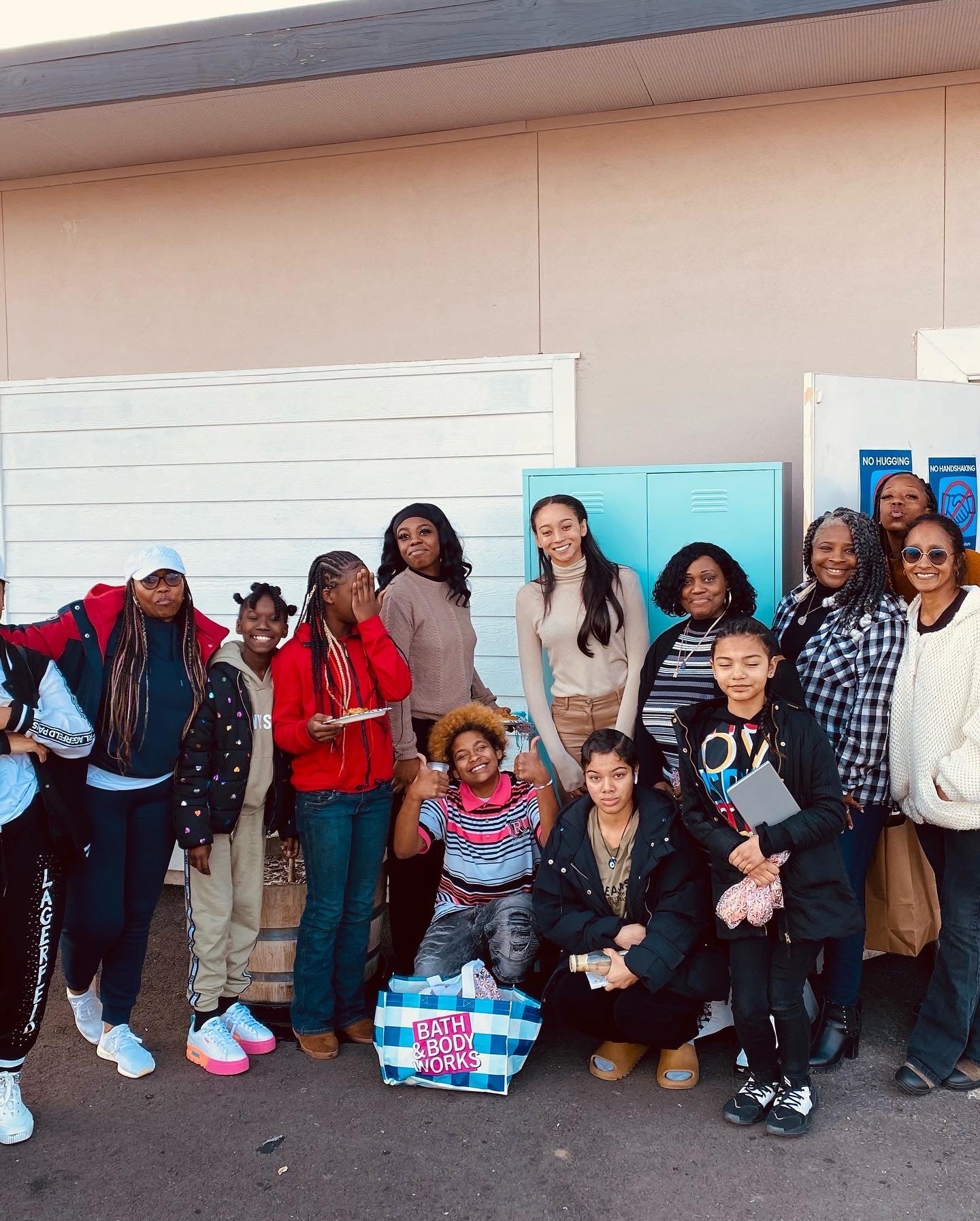 Synclair Warren stands with other women in front of a pair of lockers outside of a building